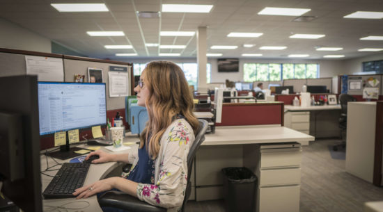 An employee at PDI in Temple, TX works at her desk