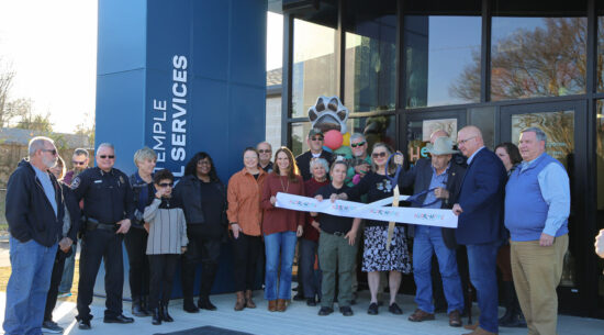 A group of people celebrate outside of Heart to Home Animal Adoption Center for the Ribbon Cutting and Grand Re-Opening