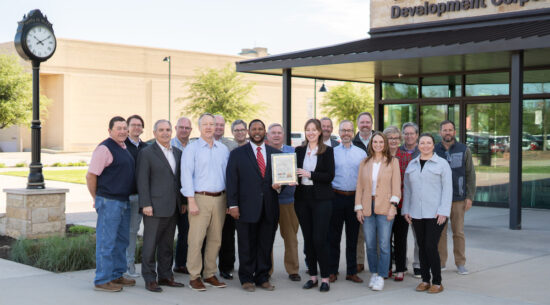 TEDC Staff stand together and present an award