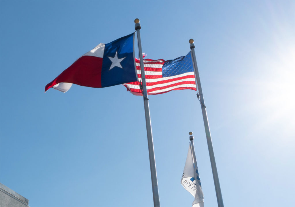 The State of Texas flag flies next to the American flag at a facility in Temple, TX